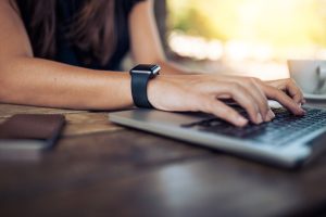 man selling items on eBay using laptop